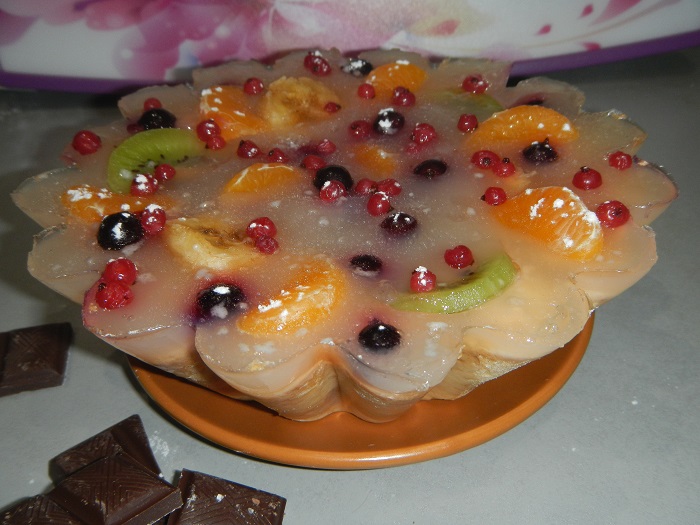 Jelly cake with fruits on a delicate sand cake