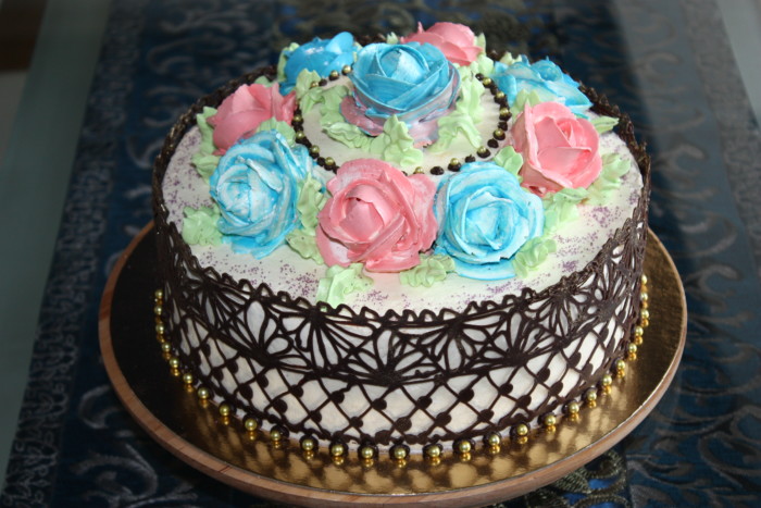 Домашній бісквітний торт з кулею, ганашем, трояндами з крему та шоколадним декором.